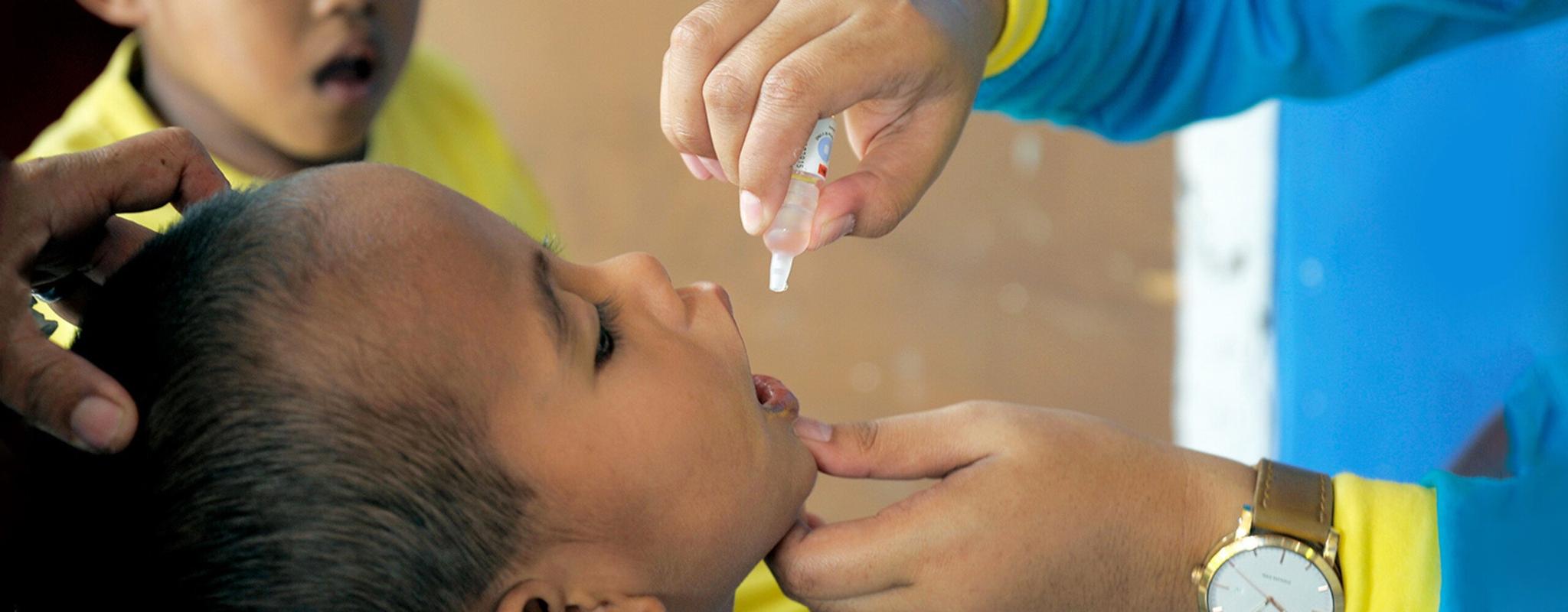 A child receiving oral polio drops 