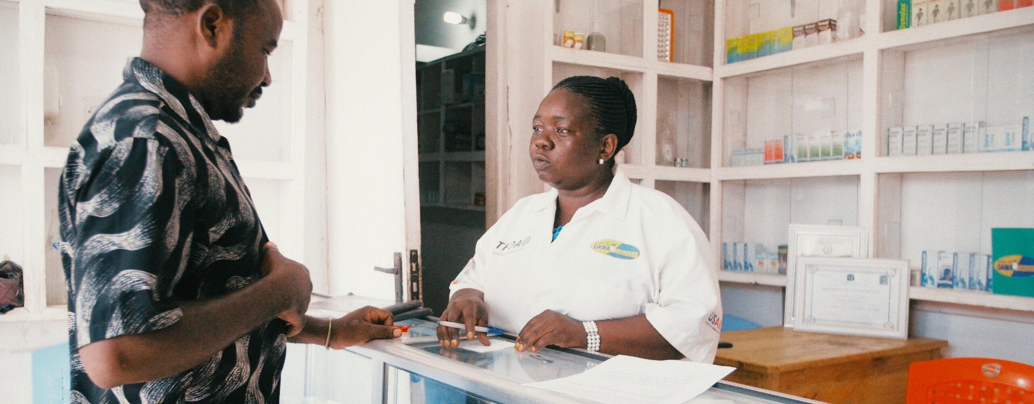 Pharmacist talks to a customer in a pharmacy.
