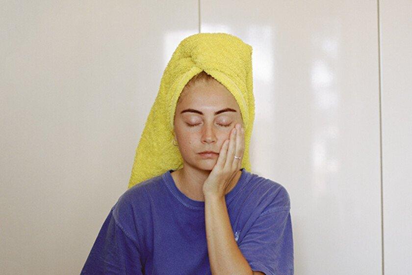 Portrait of a woman with her wet hair wrapped up in a towel