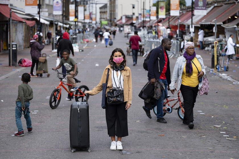 A portrait of a masked pedestrian on London's Ridley Road.