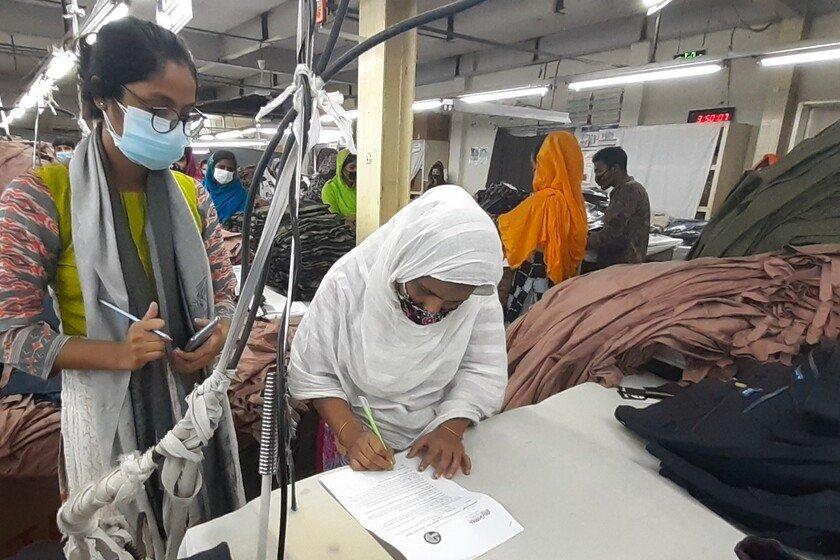 Researchers conduct a survey with workers in a ready-made garment factory.