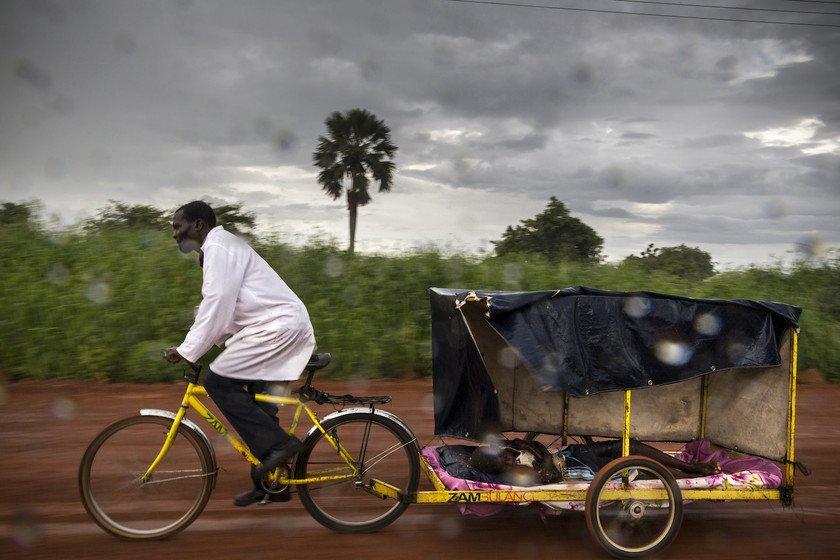 Dismuss uses his bicycle ambulance to transport a young boy with malaria to the nearest clinic. He is a volunteer community healthcare worker in Chongwe district, and is trained to test for common diseases and administer basic drugs.