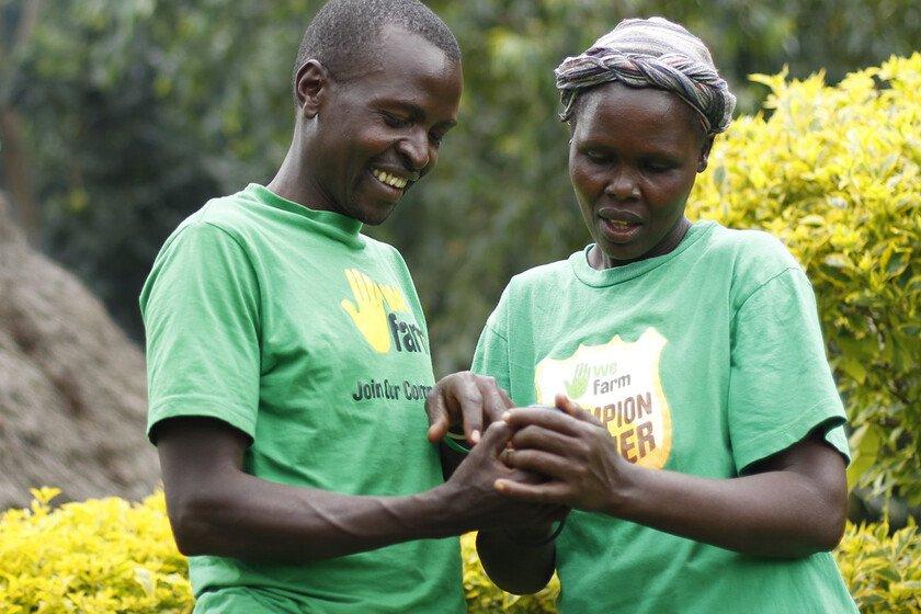 Two farmers in Kenya looking at a mobile phone.