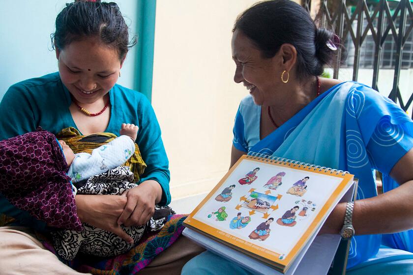 A community health volunteer with mother and her baby in the Satungal village in western Kathmandu.  