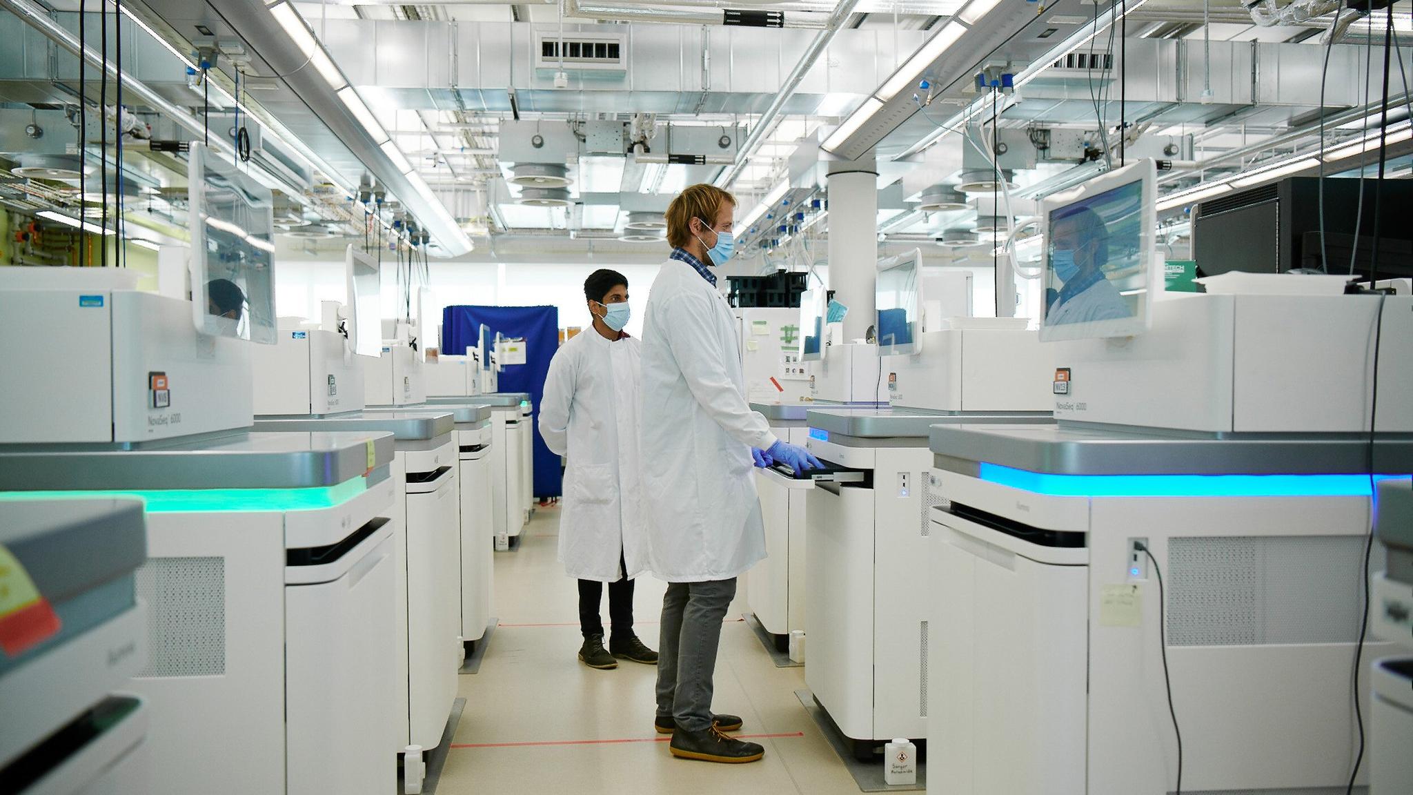 Two scientists at the Sanger Institute prepare the sequencing machines.