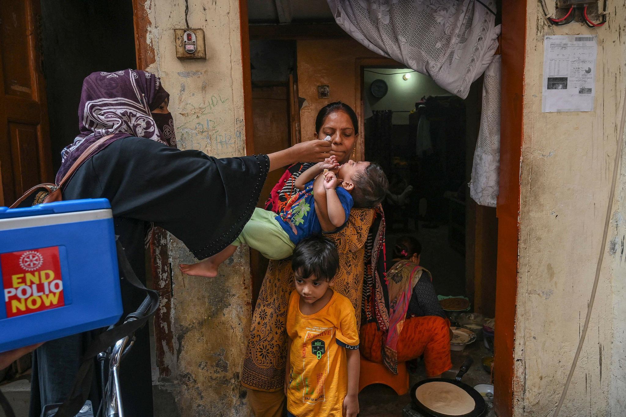 A health worker administers polio vaccine drops to a child during a polio vaccination campaign in Lahore.