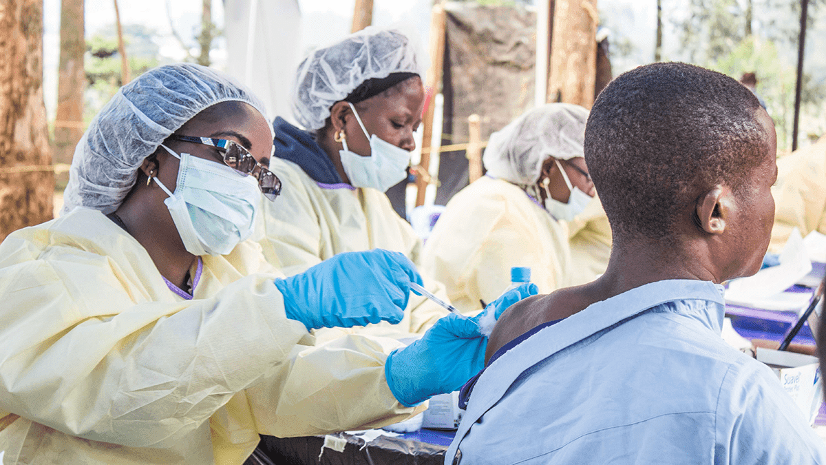 A healthcare worker gives a man an Ebola vaccination