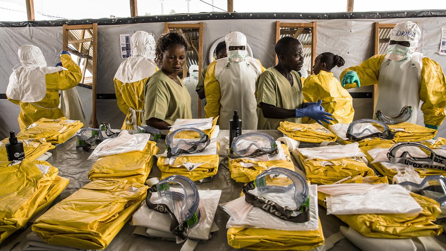 Healthcare workers put their personal protective equipment on before entering the zone with people suspected of having Ebola.