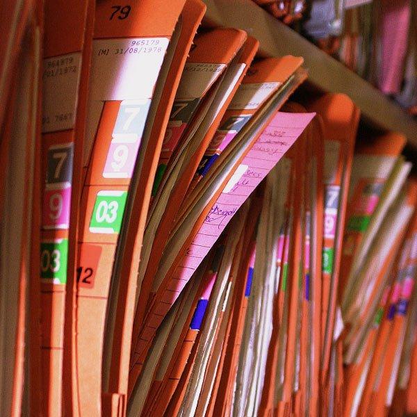 Shelves tightly packed with patients' hospital records in labelled folders