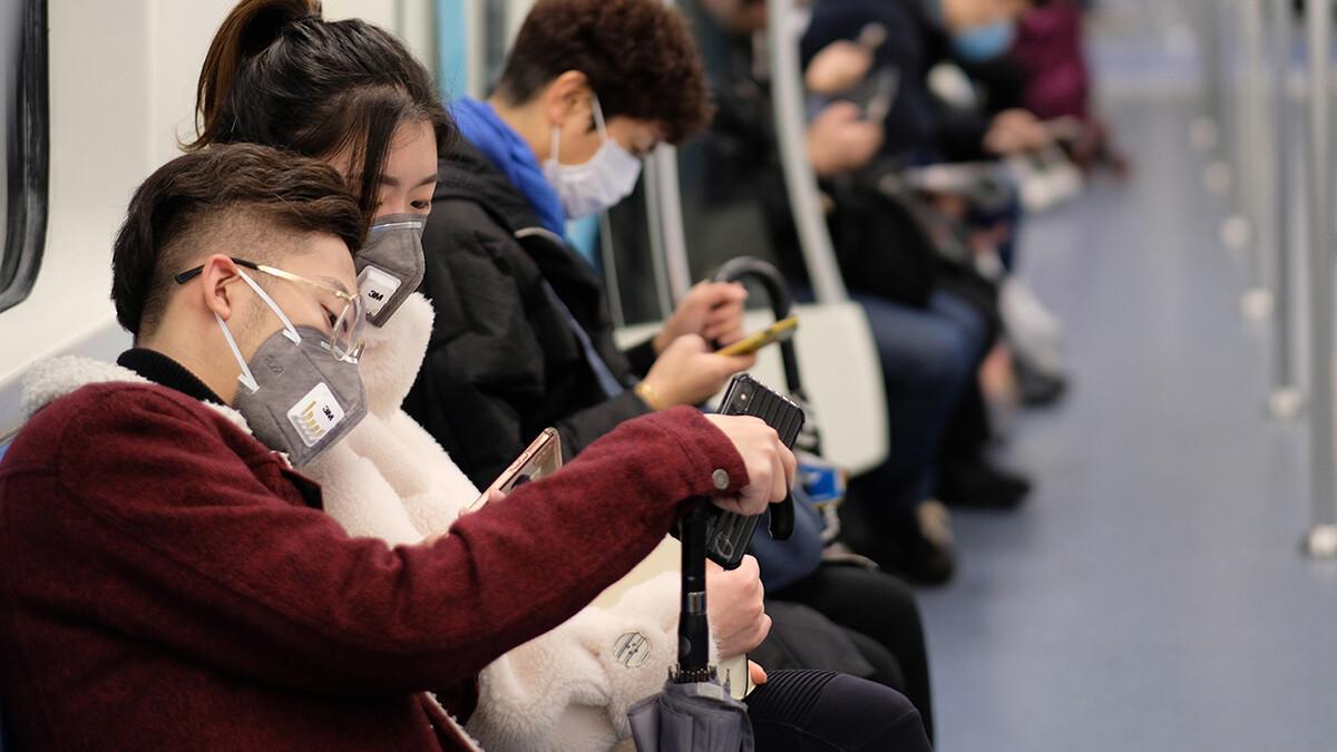 People wearing surgical masks sitting in subway in Shanghai, China. 