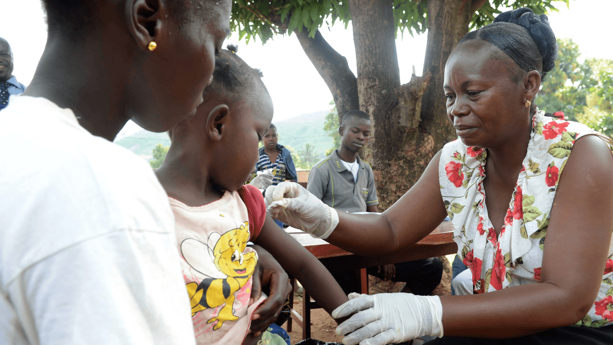 A girl gets a vaccination against measles from a health worker 